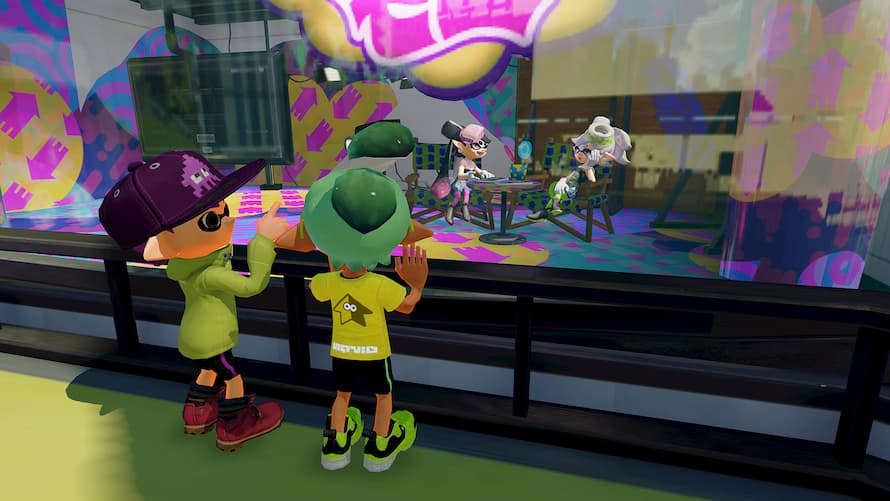 Two Inklings look on from outside as Callie and Marie sit and chat inside their studio